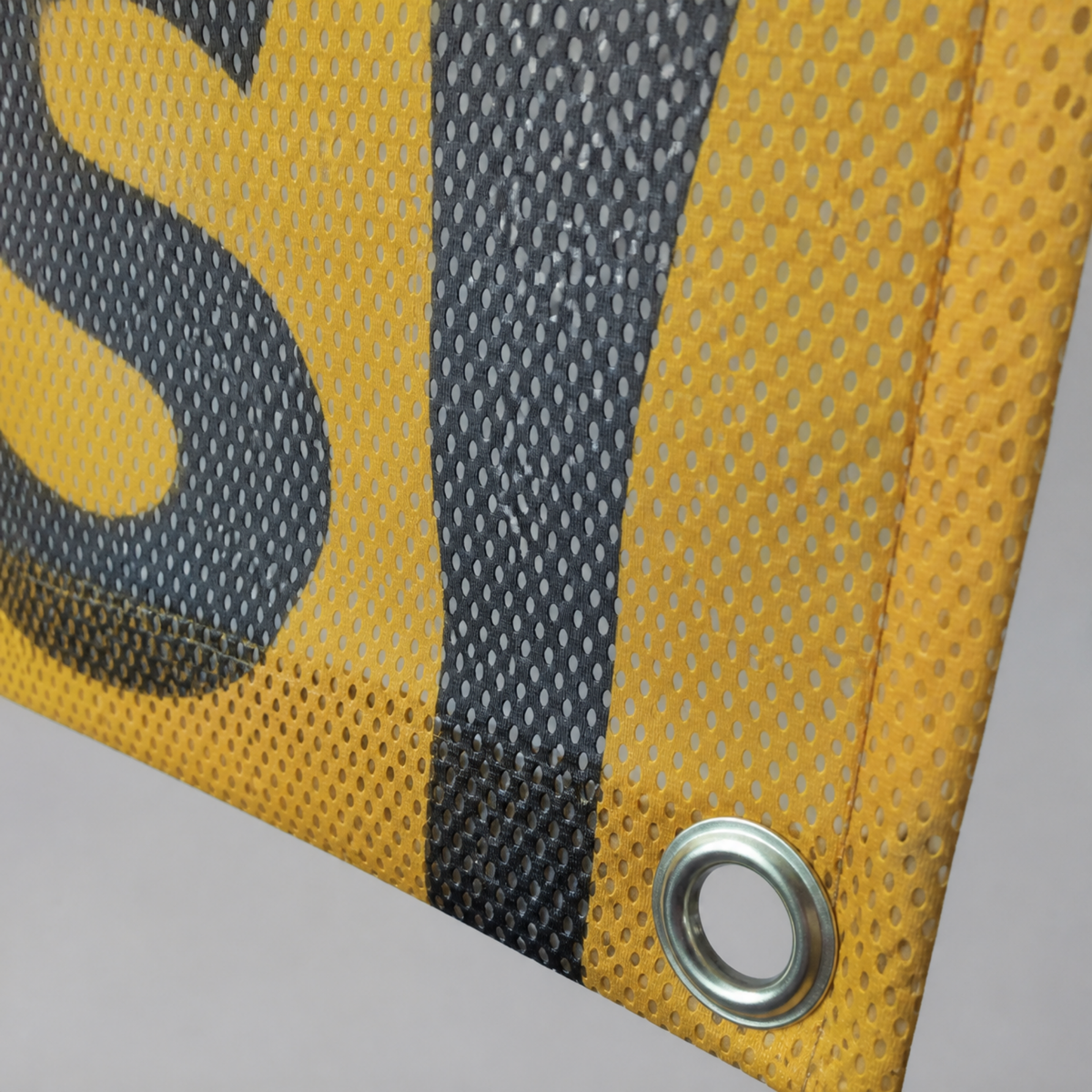 Mesh banner perforations let wind pass through