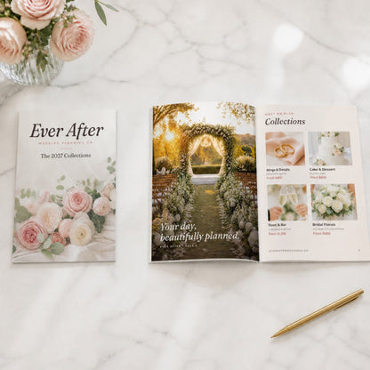 Printed 5 x 7 wedding planning guide closed and open on a marble table with roses